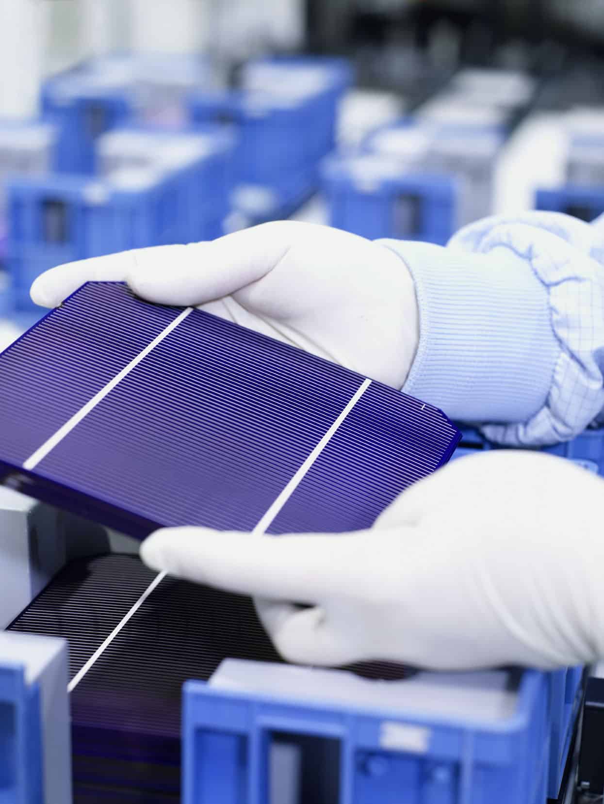 Two hands carrying a solar cell
