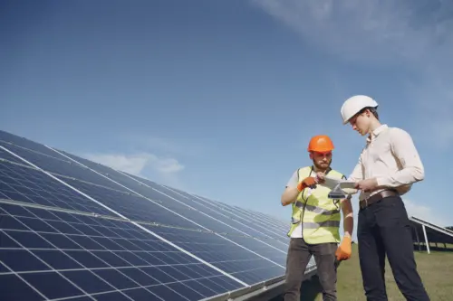A technical person and a businessman discuss a solar energy station.
