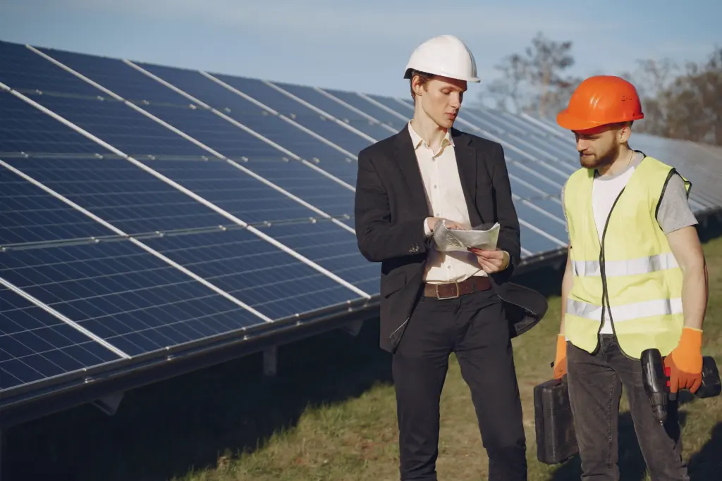 A foreman and a businessman discuss operations at a solar energy station.