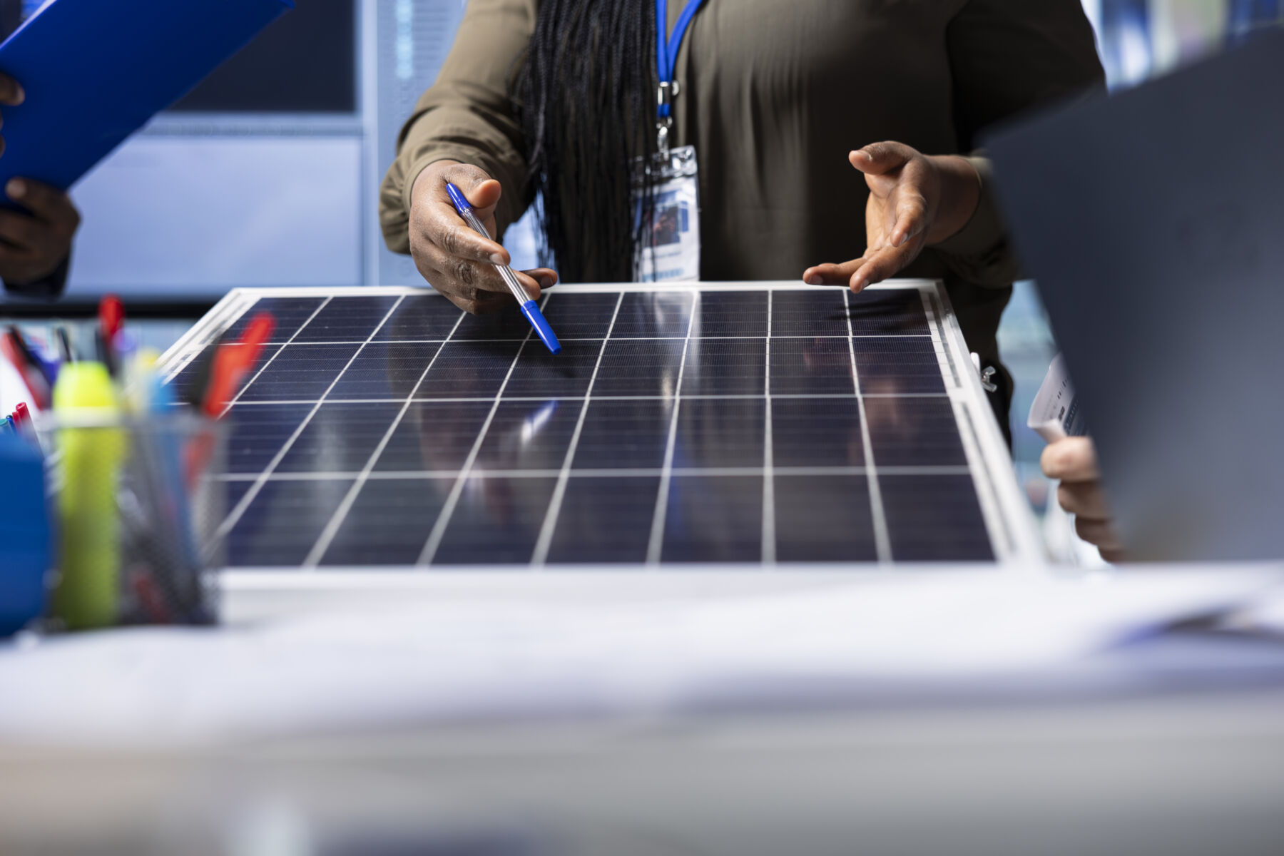 An expert meticulously reviews a solar panel design up close in a photovoltaics factory.