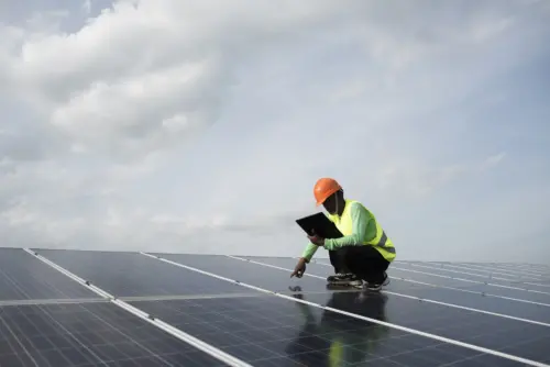 A technician inspects a rooftop solar panel.