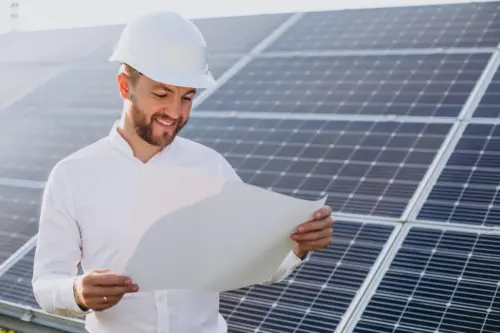 A young architect in professional attire inspects solar panels